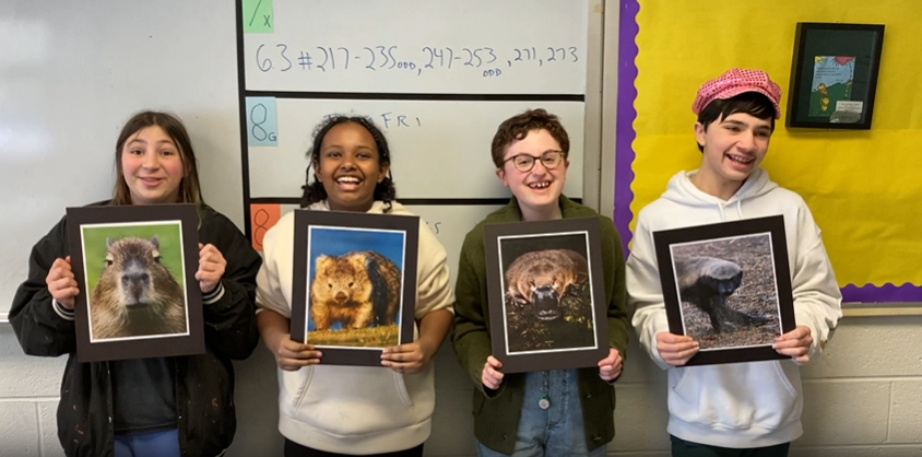 4 students hold animal posters (screenshot of a semifinalist video)