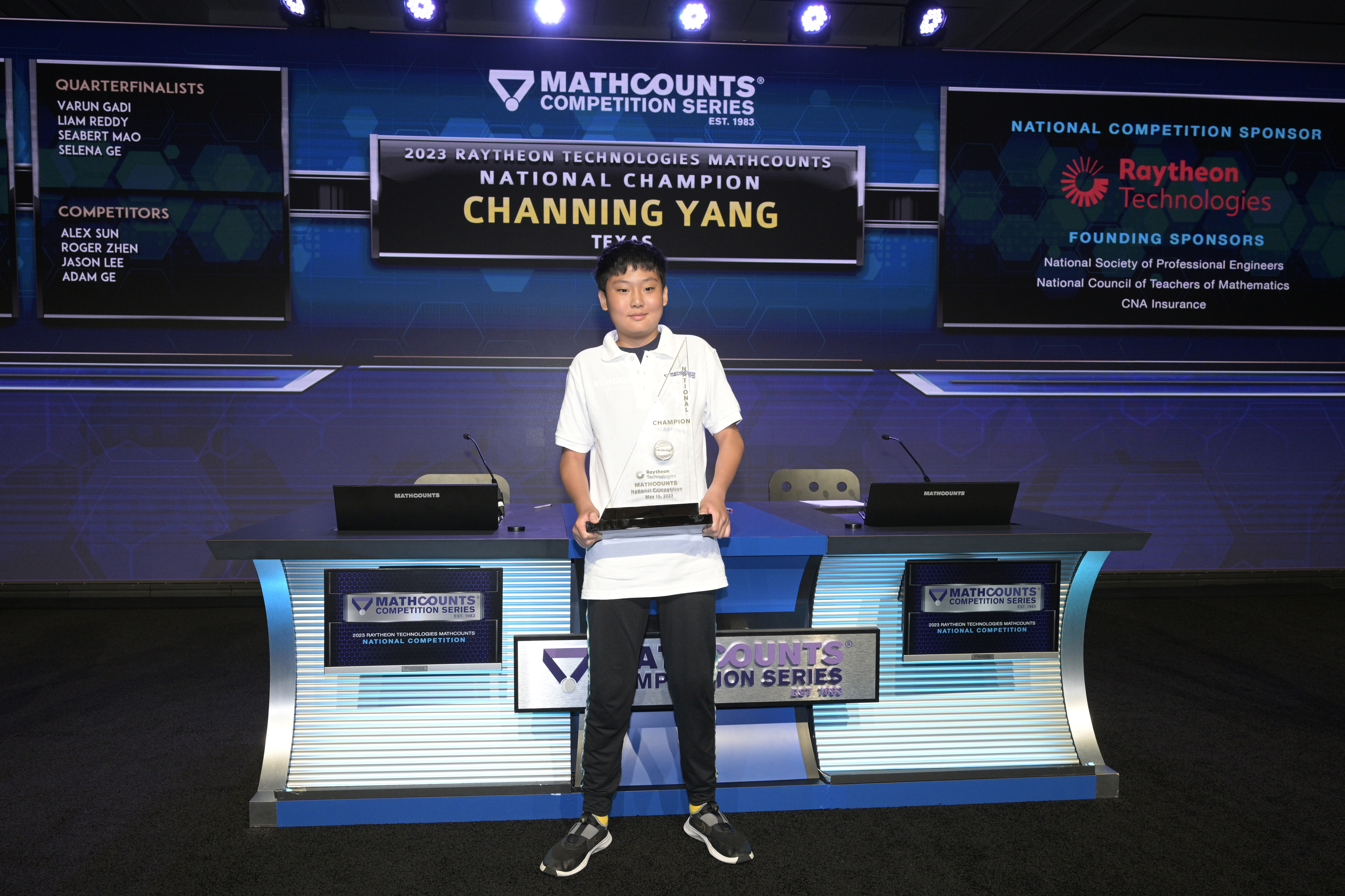 Channing Yang stands with his trophy on the MATHCOUNTS stage