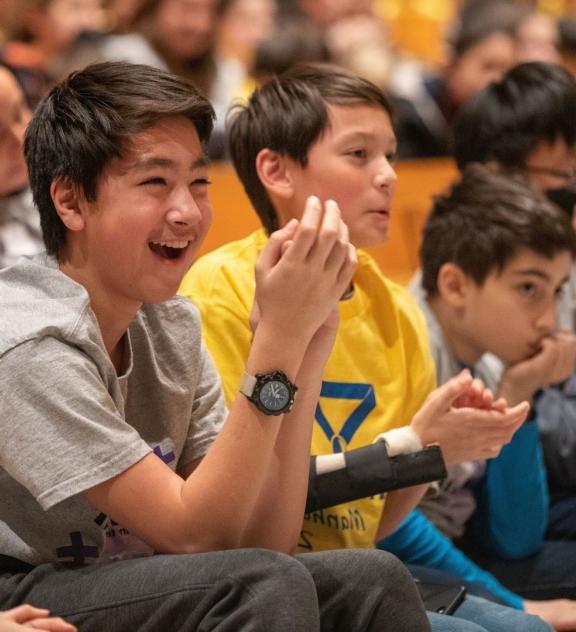 Smiling students sitting in an auditorium